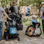 Väter mit ihren Kindern, die im Rollstuhl sitzen im Hessenpark