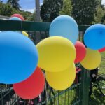 Bunte Luftballons am Zaun