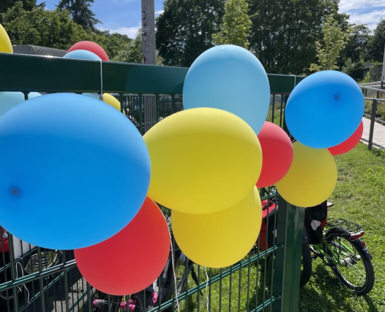 Bunte Luftballons am Zaun