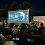 Publikum sitzend vor der Leinwand